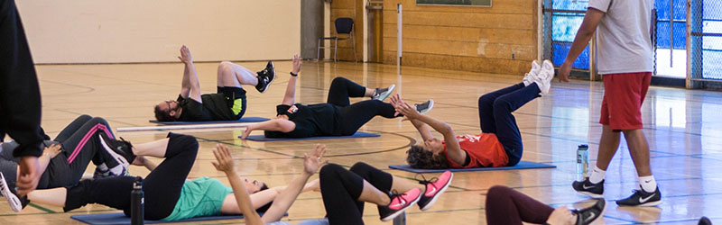 people exercising on mats in gym