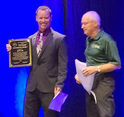 Matt Lee holds SWACSM recognition award plaque