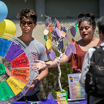 public health students at table display with colored wheel