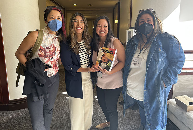 Valerie Francisco-Menchavez holds book with three editors