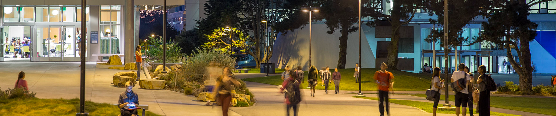 students walking in front of library at night