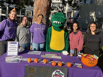Student group behind table with gator
