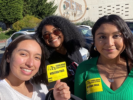 3 public health students in front of a high school